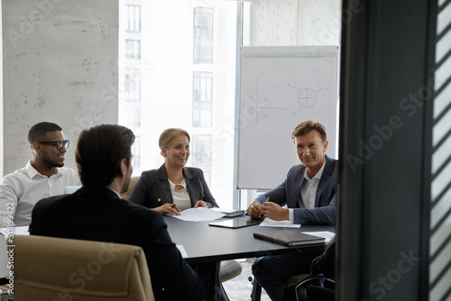 Tableau sur toile In modern office board room team of young and middle-aged diverse businesspeople take part in group meeting