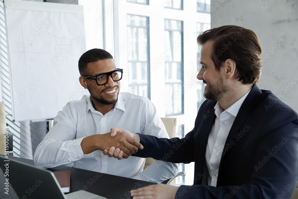 Young African and Caucasian businessmen handshaking accomplish meeting ...