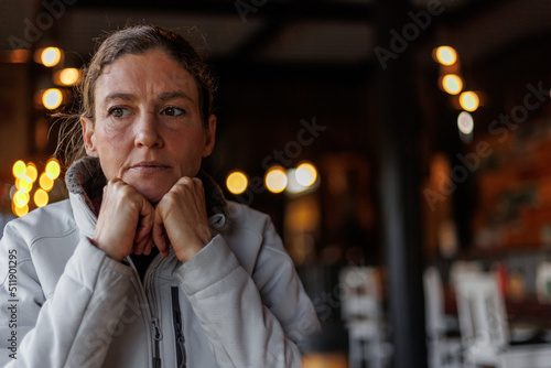 woman deep in thought sitting in a coffee shop
