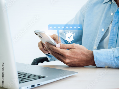 Two factor authentication concept. Virtual safety shield icon while access on phone with laptop for validate password, Identity verification, cybersecurity with biometrics authentication technology. photo