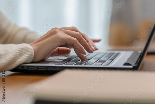 Close up hand of business woman typing on keyboard working with computer laptop. Hands of woman chatting or writing article on work table at home. B roll typing to communication on computer