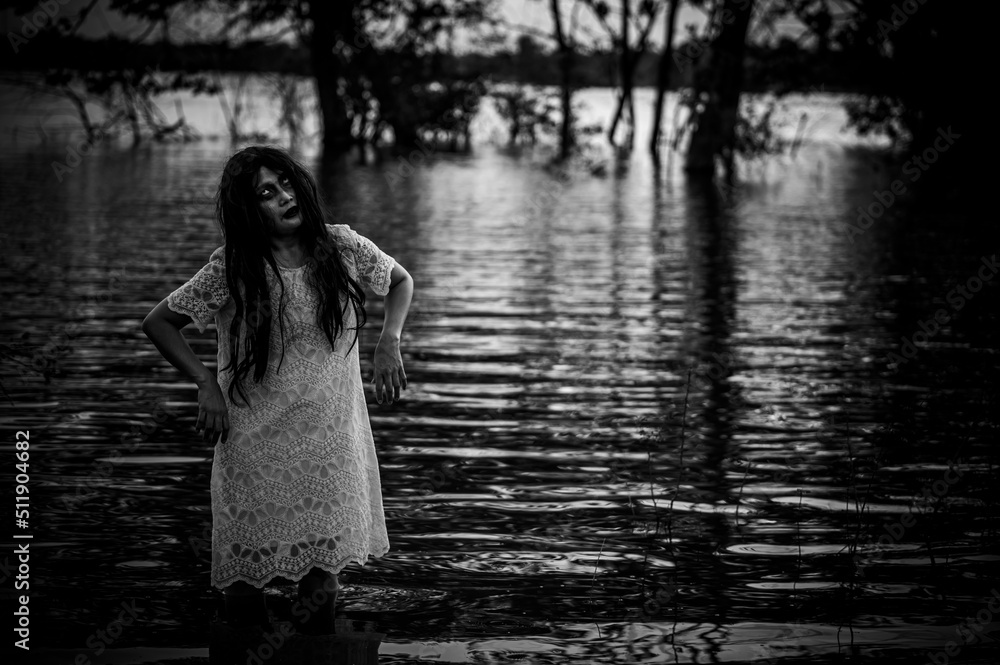 Naklejka premium Portrait of asian woman make up ghost face at the swamp,Horror in water scene,Scary at river,Halloween poster,Thailand people
