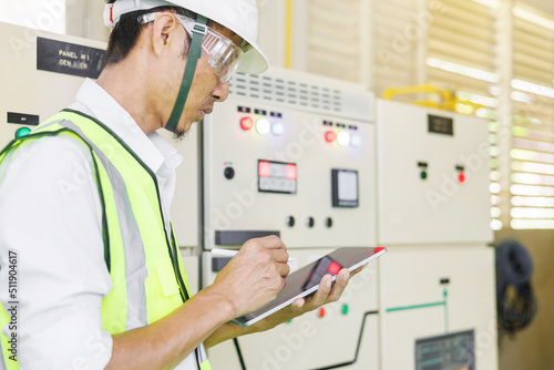Electrical engineer holding tablet computer tools to inspecting the electrical system in a factory, energy concept.