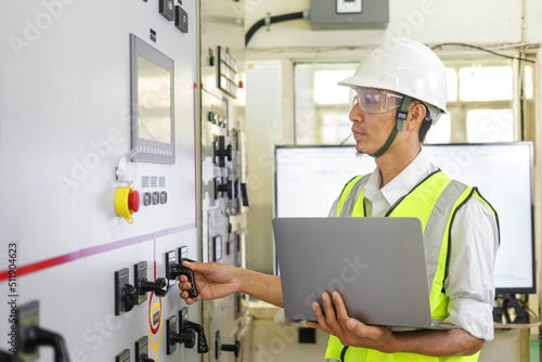 Electrical engineer holding a tablet computer tools to inspecting the electrical system in a factory, energy concept.
