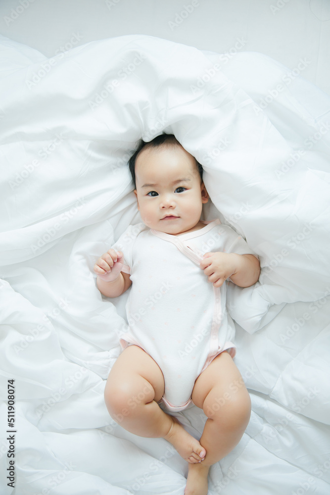 Cute little asian baby on bed with soft blanket indoors Cute little asian baby on bed with soft blanket indoors