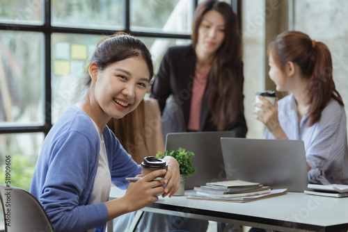 Asian teenage women sit in a startup company meeting room, young generation co-found and develop a plan to grow and differentiate a startup company. Startup company development by new generation.