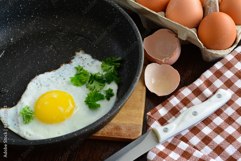 fried egg with yolk on frying pan on cutting board, close-up fried egg with yolk on frying pan on cutting board, close-up