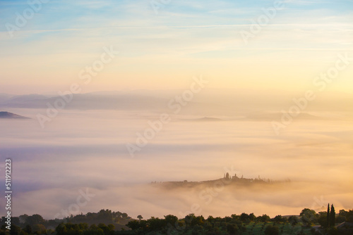 Picturesque view of countryside  of Tuscany in the light of the rising sun in foggy morning  Italy