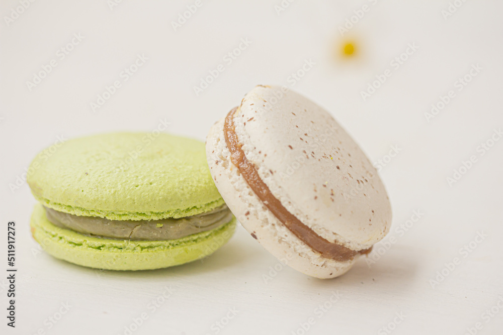 Green and white macarons on white background. Salted caramel macaroon, Pistachio nut macaroon. Summer dessert Green and white macarons on white background. Salted caramel macaroon, Pistachio nut macaroon. Summer dessert
