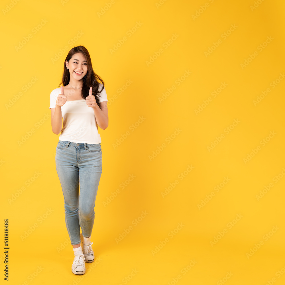 Smiling asian woman white shirt on yellow background with thumbs up show appreciate Smiling asian woman white shirt on yellow background with thumbs up show appreciate