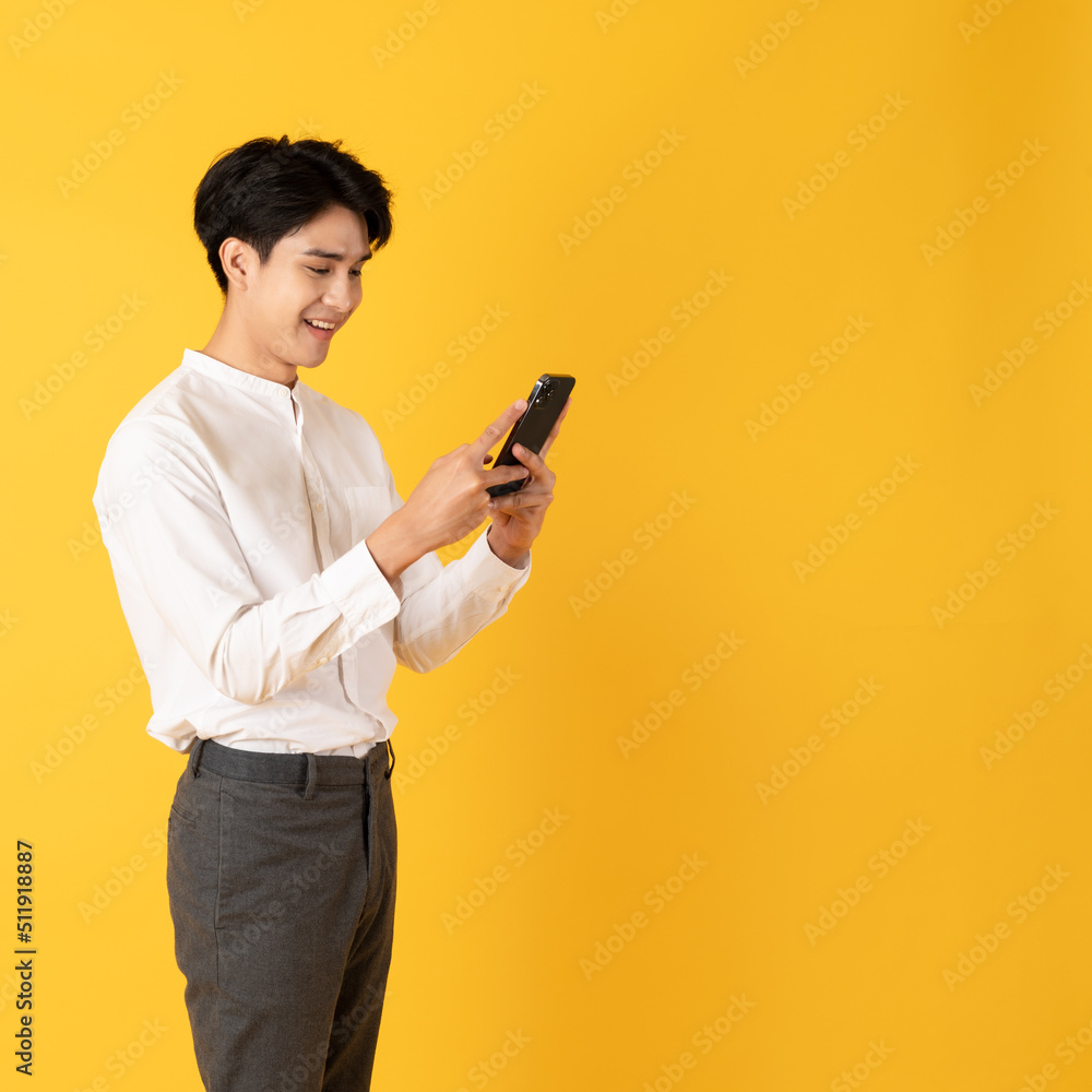 Good looking teenage asian man with laugh isolate on yellow background Good looking teenage asian man with laugh isolate on yellow background