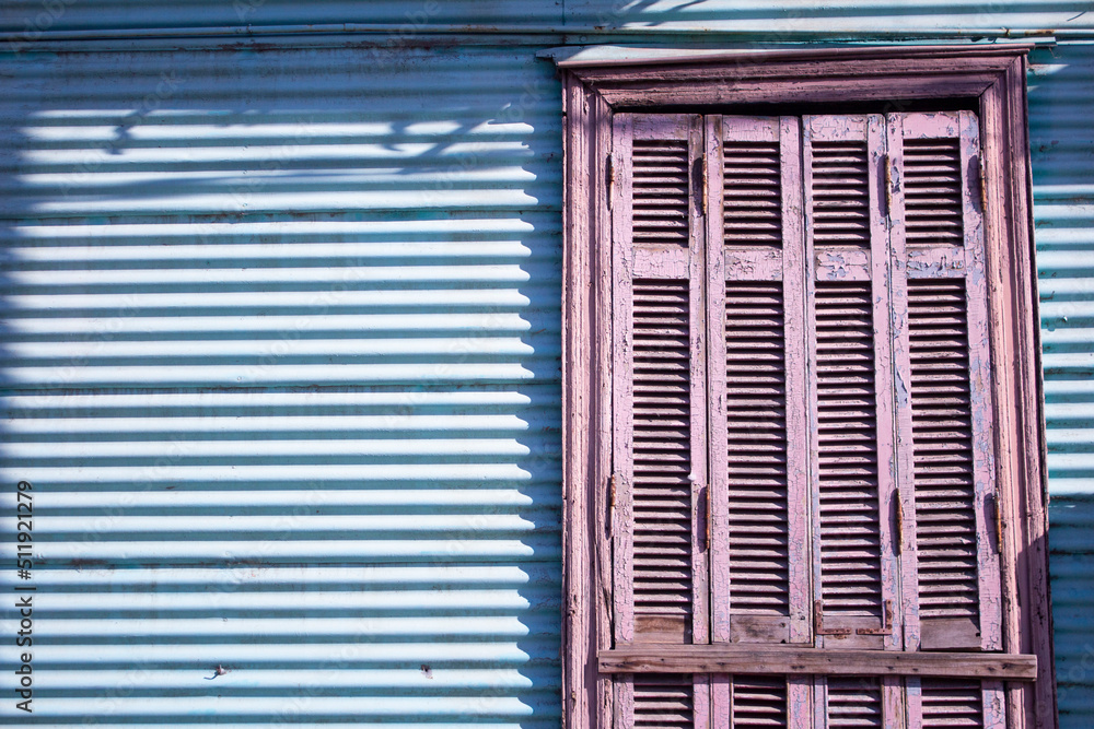 Fototapeta premium CASA ANTIGUA AZUL DE LÁMINA CON PUERTA MORADA DE MADERA 