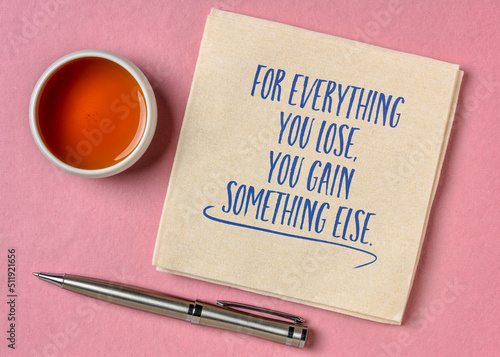 for everything you lose, you gain something else - inspirational reminder note, handwriting on a napkin with a cup of tea, optimism, positivity and personal development concept photo