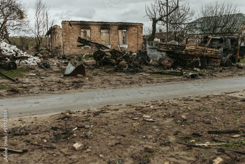 Burned car on the background of a destroyed house in the Ukrainian village