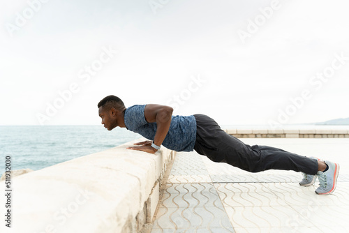Mixed race athletic man with muscular body doing push ups exercise