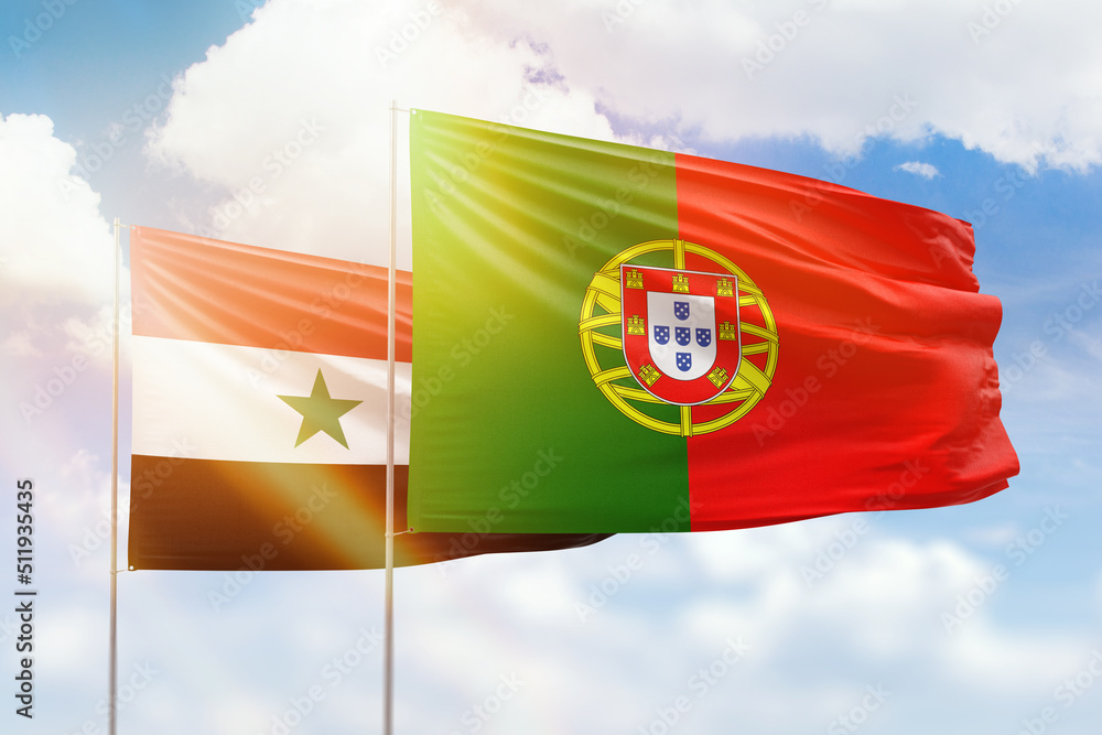 Sunny blue sky and flags of portugal and syria Sunny blue sky and flags of portugal and syria