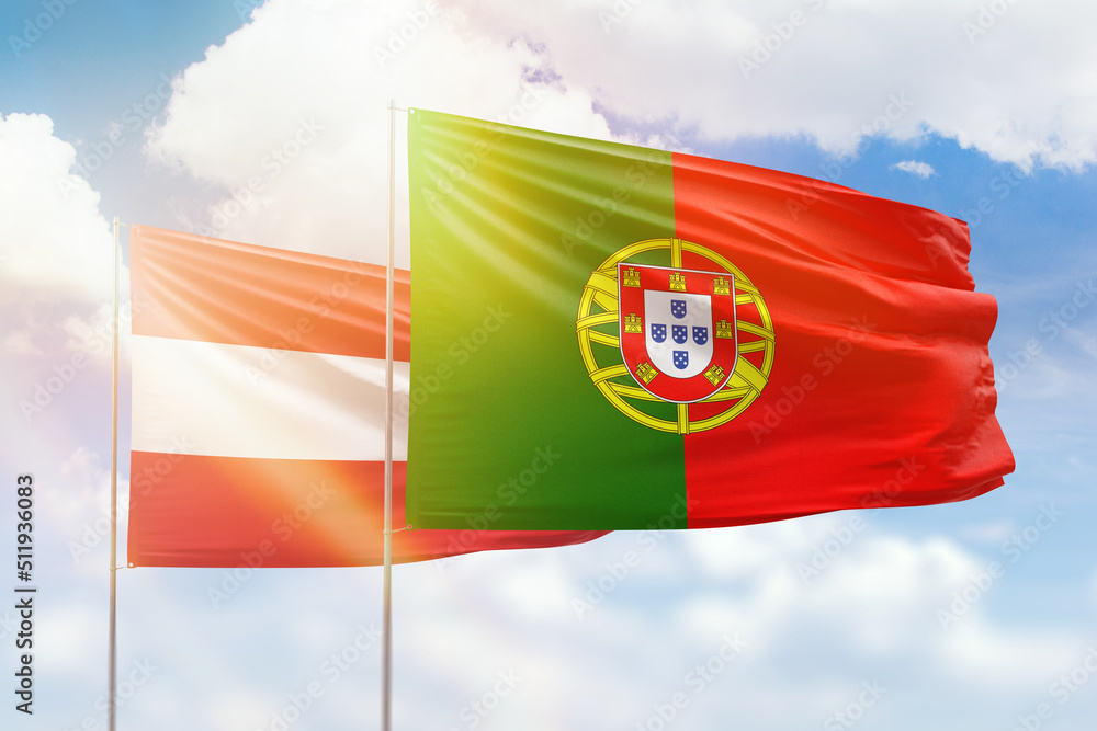 Fototapeta premium Sunny blue sky and flags of portugal and austria