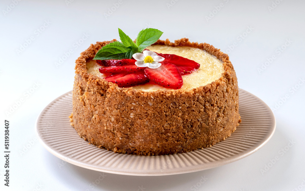 New York cheesecake is a dessert that is an open pie or even a cake. Decorated with strawberries. It consists of two main parts: sand base and cheese filling. White background. New York cheesecake is a dessert that is an open pie or even a cake. Decorated with strawberries. It consists of two main parts: sand base and cheese filling. White background.