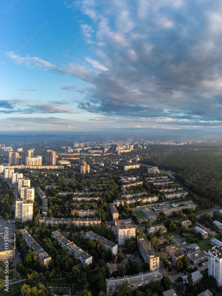 Early morning cityscape vertical view in summer green city, residential district with blue sky. Aerial cityscape above buildings and streets, Pavlovo Pole, Kharkiv Ukraine