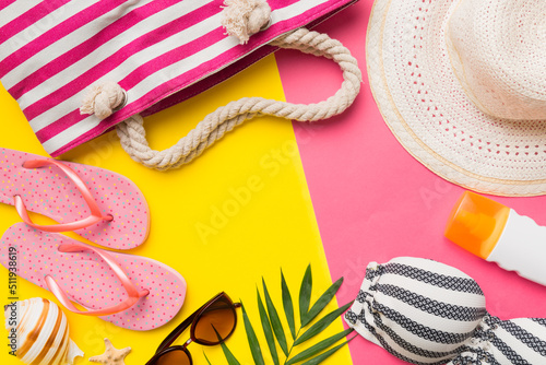 Beach accessories straw hat and seashell on colored table. Summer concept background