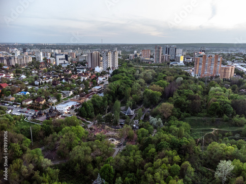Aerial view on green summer Kharkiv city center popular recreation park Sarzhyn Yar and modern residential district. Botanical garden with water spring and sports playground area