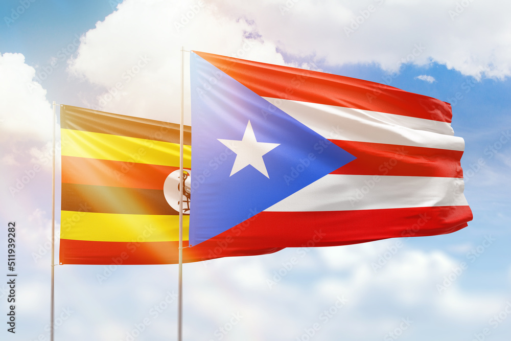 Sunny blue sky and flags of puerto rico and uganda Sunny blue sky and flags of puerto rico and uganda
