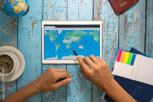 Pen pointed at the map. The map is shown in digital form on a tablet. Planning a vacation ahead. Travel concept © Small365