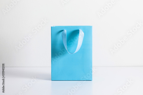 Blue bag on white background. Blue shopping paper bag with handles.