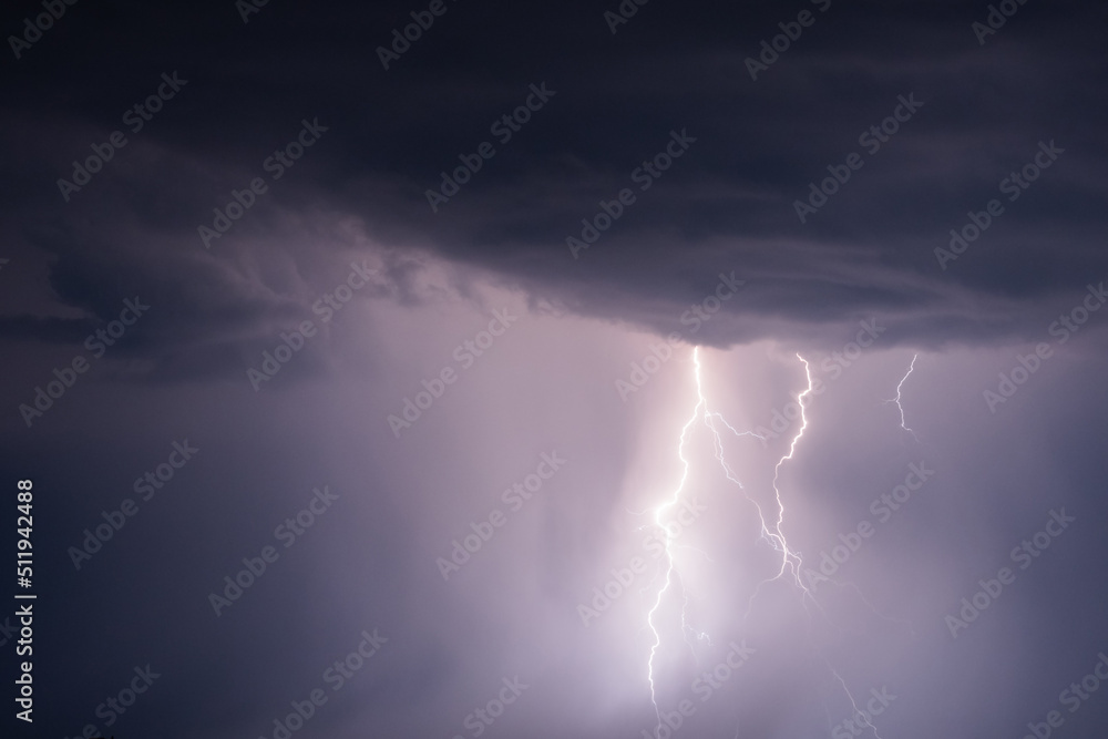 Dark stormy sky with lightning strikes and thunderstorm clouds at night. Dramatic, nature, danger, weather and atmosphere concept