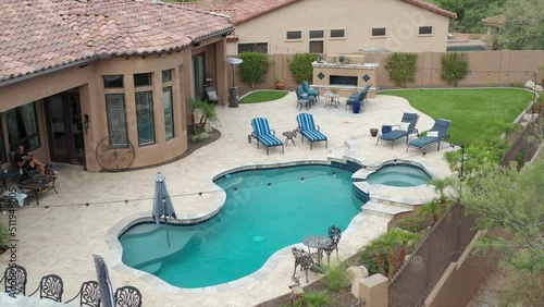 A desert landscaped backyard in Arizona featuring a travertine tiled pool deck.
