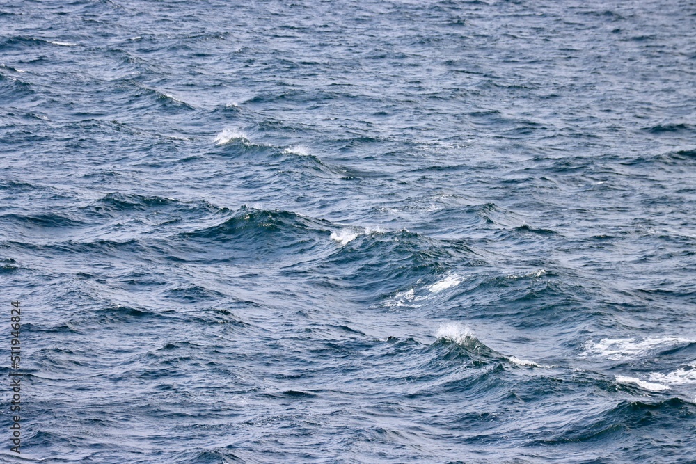 Waves far in open Baltic sea. Deep blue water, white foam on top of waves. Photo taken from ship