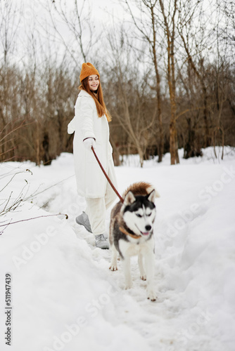 Fototapeta Naklejka Na Ścianę i Meble -  portrait of a woman outdoors in a field in winter walking with a dog fresh air