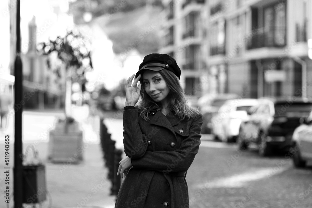 Beautiful slender woman in a cap in the street in black and white