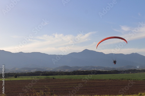 Paragliding sail against the background view of rice plantation in Brazil