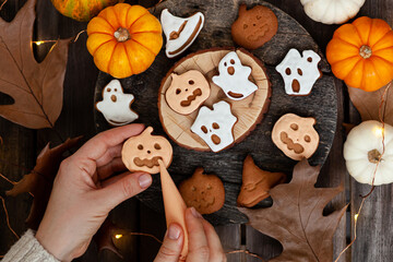 Homemade halloween holiday treats for kids. Gingerbread cookies on wooden board, decorated with pumpkins and autumn leaves. Top view