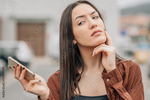 Картината върху платно girl with mobile phone and distrustful expression