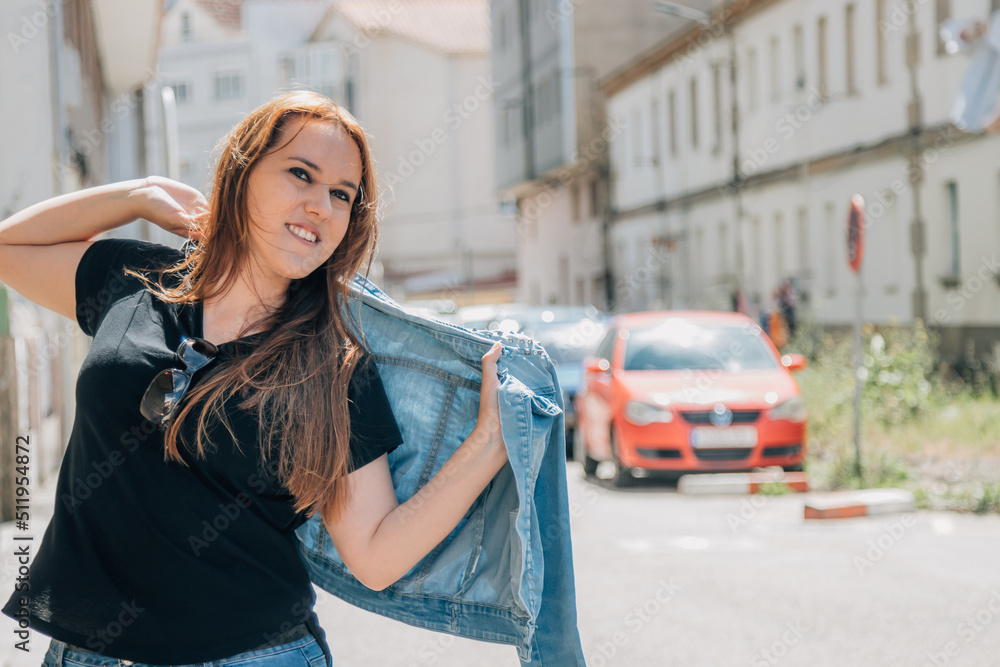 girl in the street putting on her jacket