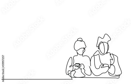 man and  woman are sitting next to each other using a phone