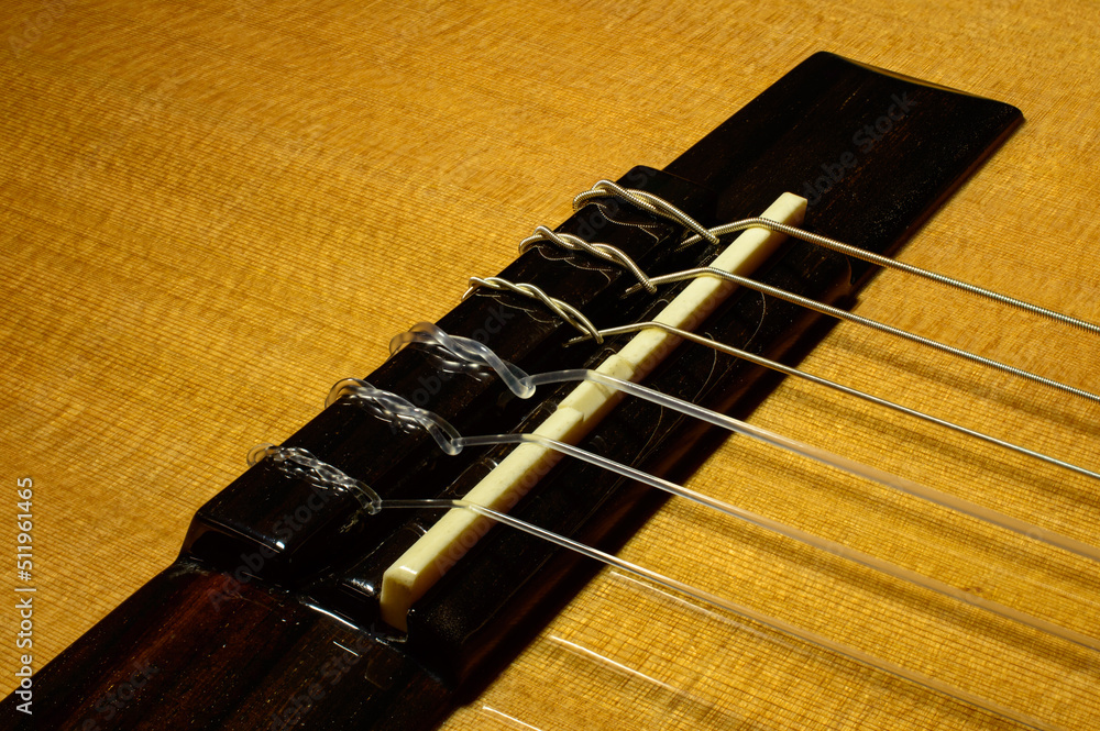 Foto de Macro photo of a guitar bridge with tail pieces of a nylon ...