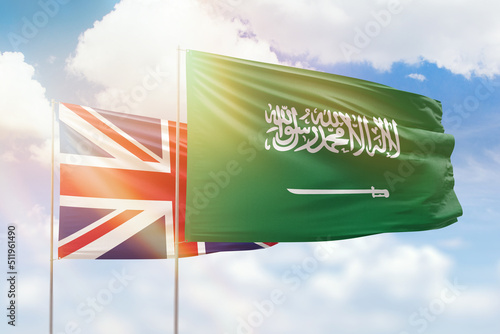 Sunny blue sky and flags of saudi arabia and united kingdom