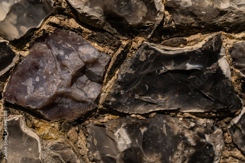 Closeup on various flint stones used in UK as a building material in architecture. Flint is the hardest of building stones, used by the Romans for castle walls and by medieval masons for churches