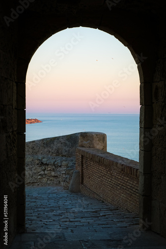 Sunset seen through the arch of Santa Barbara castle, Alicante, Spain. photo