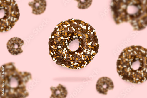 Glazed brown sweet sugar chocolate doughnut donut dessert on pink pastel background. Creative minimal blurred selective focus collage food concept