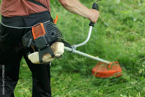 Person mowing the grass with a brushcutter