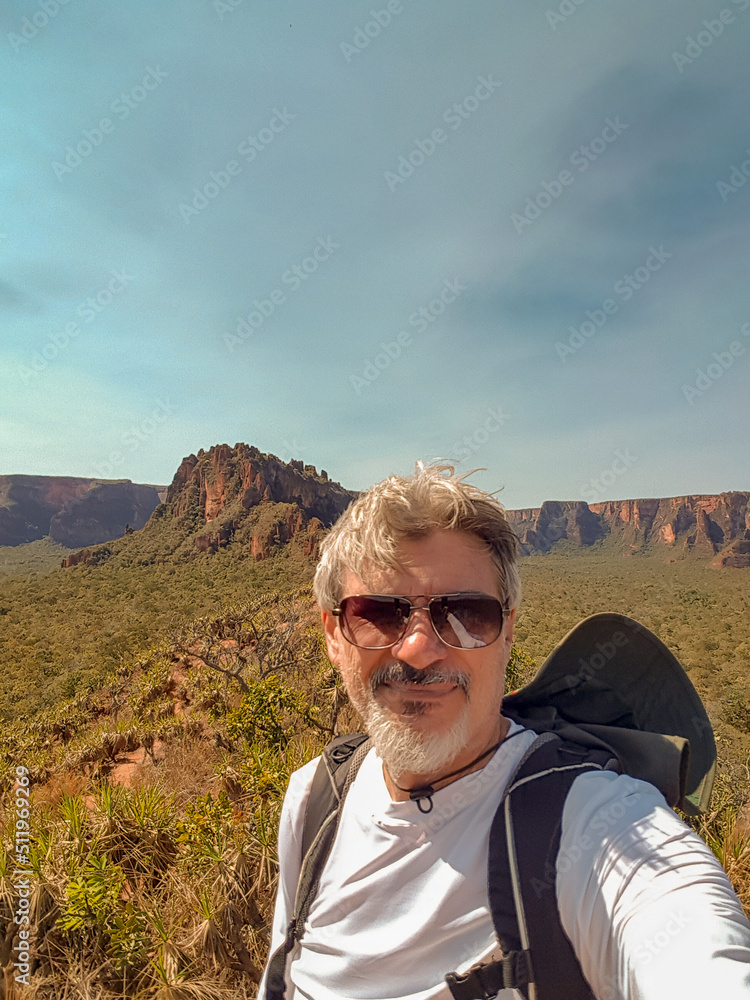 White haired man with sunglasses in front of the mountains White haired man with sunglasses in front of the mountains