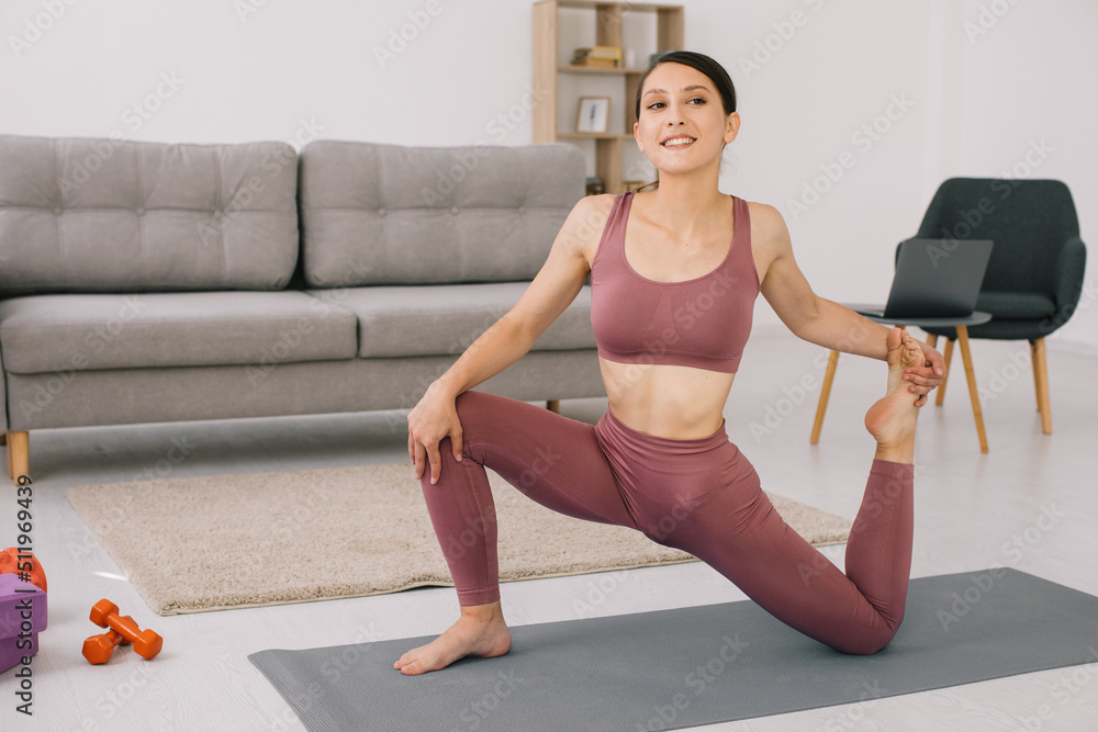 Attractive and healthy young woman doing exercises while resting at home