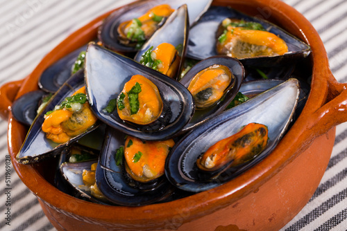 Image of mussels with sauce on the plate indoors.