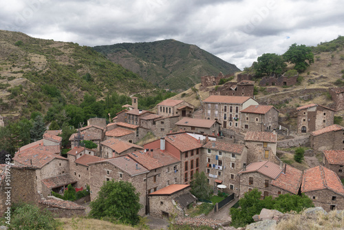Village called Viniegra de Arriba surrounded by mountains with cloudy sky, Spain.
