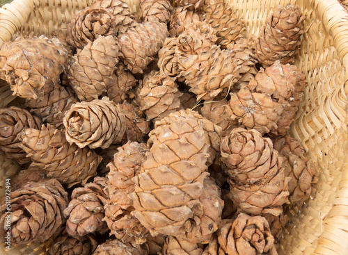 Pine cones in a wooden basket close-up. Organic food  eco food farm shop. Skins  nuts - autumn agricultural background photo