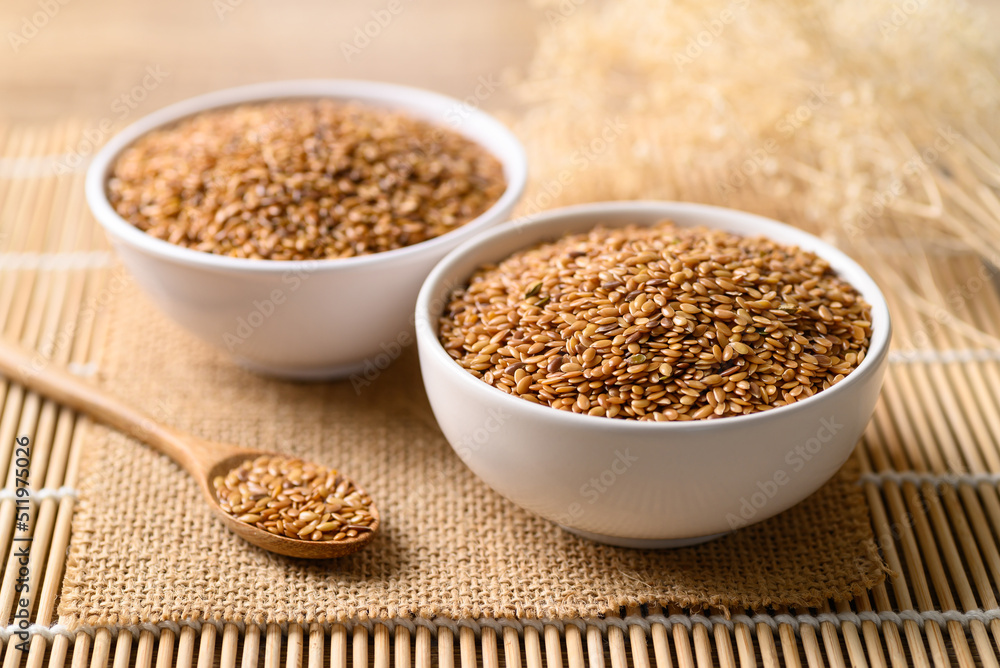 Golden flax seed or linseed in bowl with spoon Golden flax seed or linseed in bowl with spoon